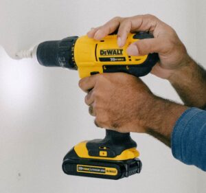 Cheaper to Buy or Rent in Denver - Image of Someone Holding a Yellow Drill